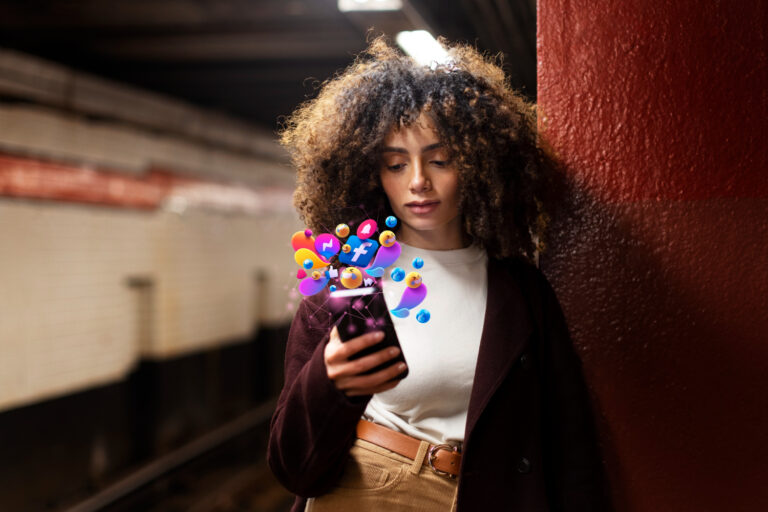 Mulher segurando um celular, com ícones e redes sociais saltando à tela.