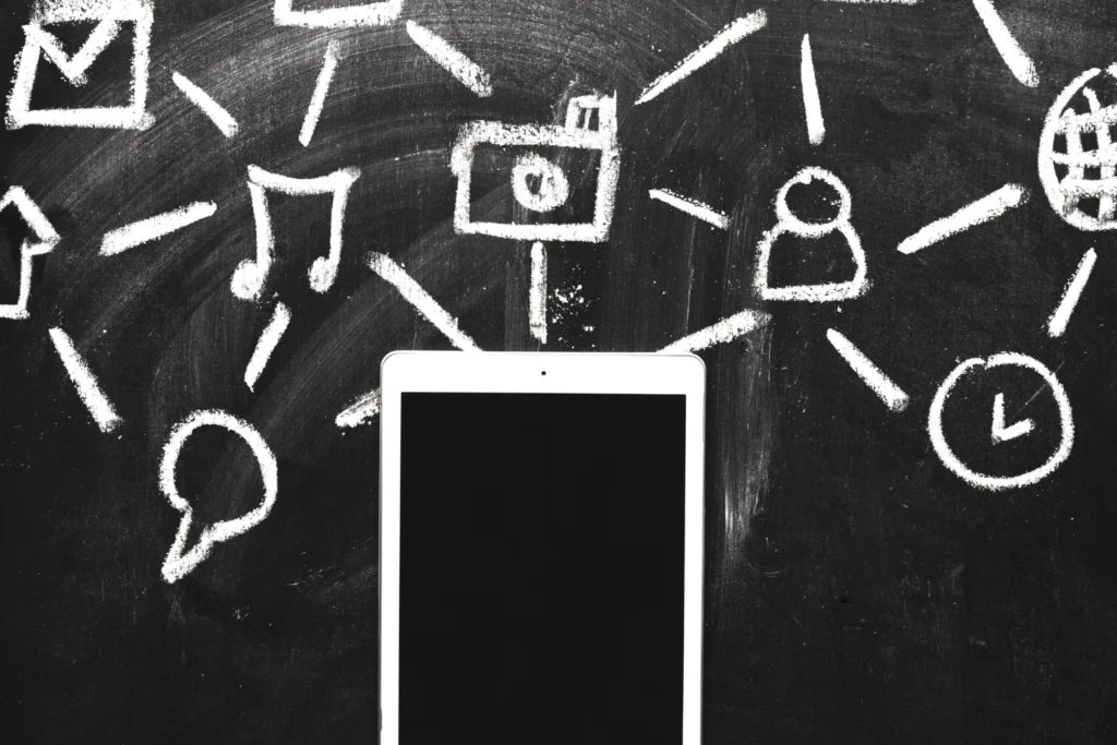 Marketing conversacional: smartphone em frente a uma lousa com vários símbolos