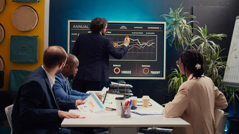 Marketing e vendas industrial: equipe em reunião analisando gráficos e documentos.