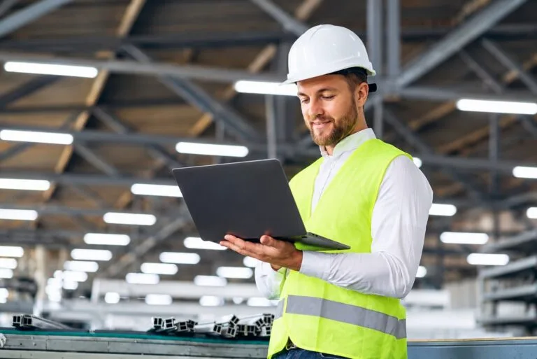 IA em propostas comerciais: engenheiro segurando notebook em ambiente fabril.